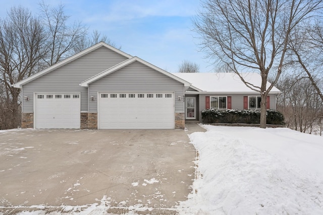 ranch-style home featuring a garage, stone siding, and driveway