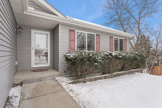 snow covered property entrance with fence