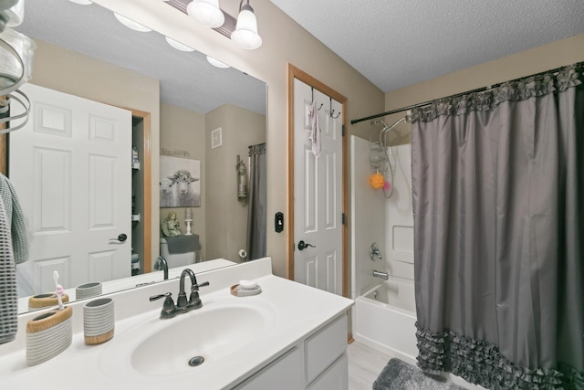 bathroom featuring shower / bath combo, hardwood / wood-style floors, vanity, and a textured ceiling