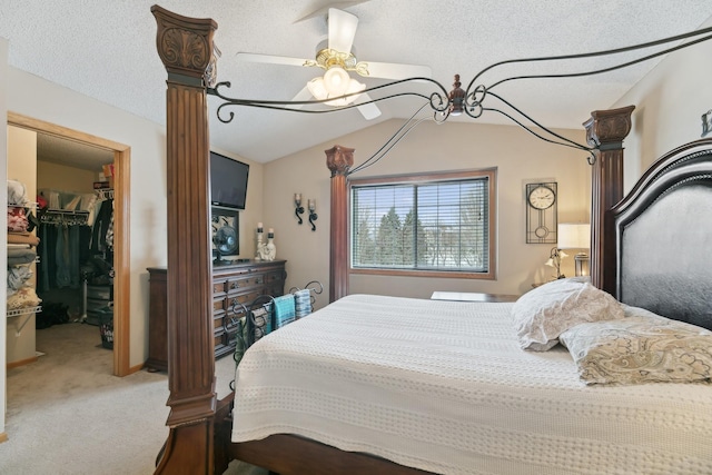 bedroom featuring lofted ceiling, carpet flooring, a spacious closet, a textured ceiling, and a closet