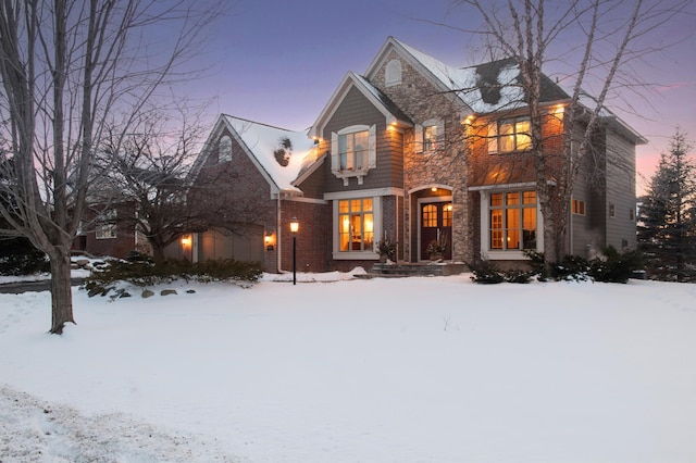 view of front facade featuring a garage, stone siding, and brick siding