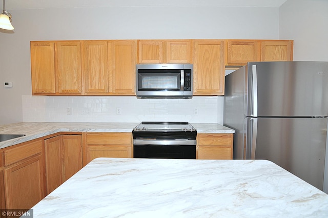 kitchen featuring appliances with stainless steel finishes, pendant lighting, light brown cabinets, and decorative backsplash