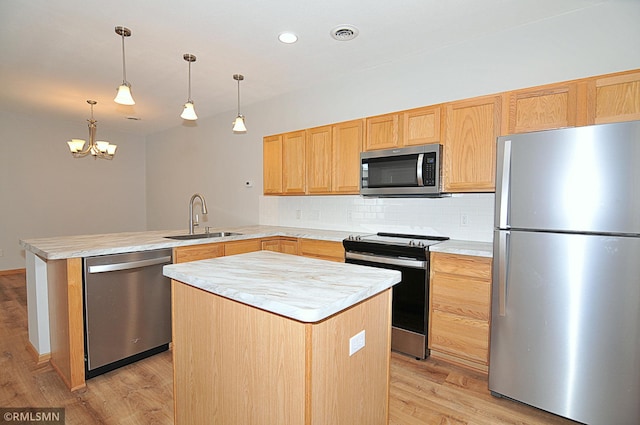 kitchen featuring a center island, appliances with stainless steel finishes, sink, and light hardwood / wood-style floors