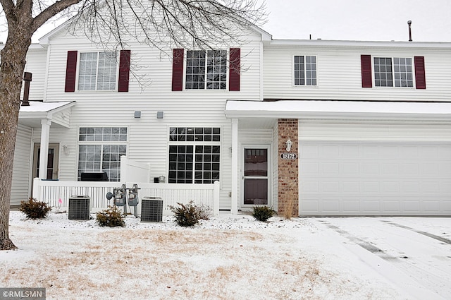 townhome / multi-family property with a garage and central AC unit