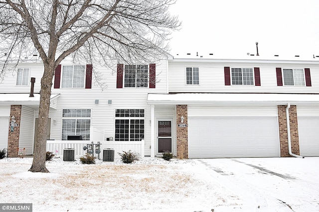 view of front of property with a garage and central AC