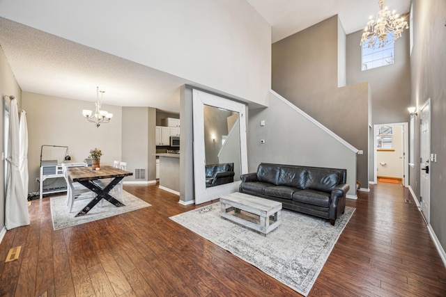 living room featuring dark hardwood / wood-style floors, a textured ceiling, and a chandelier