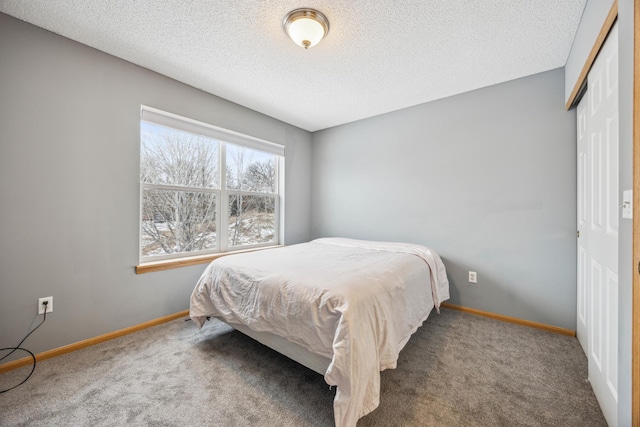 carpeted bedroom with a closet and a textured ceiling