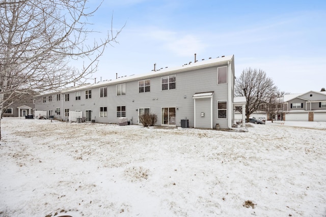 snow covered house with central AC unit