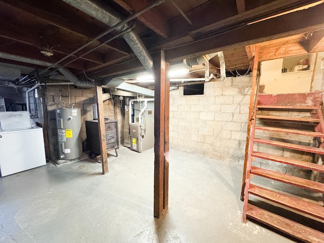 unfinished basement with water heater, heating unit, and washer / dryer