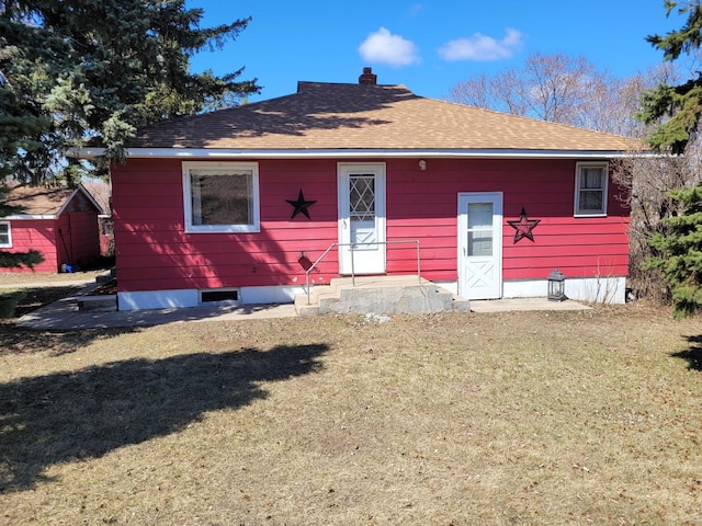 view of front facade featuring a chimney, roof with shingles, and a front yard