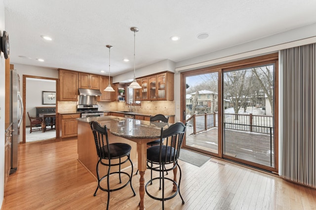 dining area featuring sink, light hardwood / wood-style flooring, and a textured ceiling