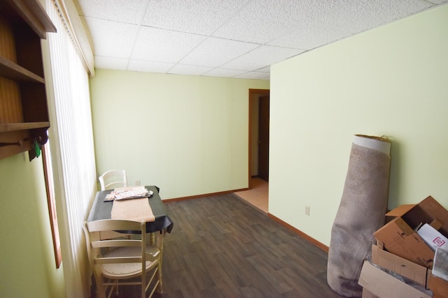 interior space with dark hardwood / wood-style floors and a drop ceiling