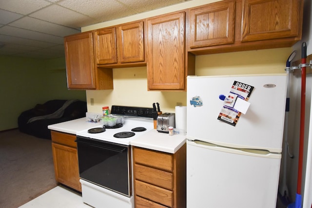 kitchen with white refrigerator, a drop ceiling, and electric stove