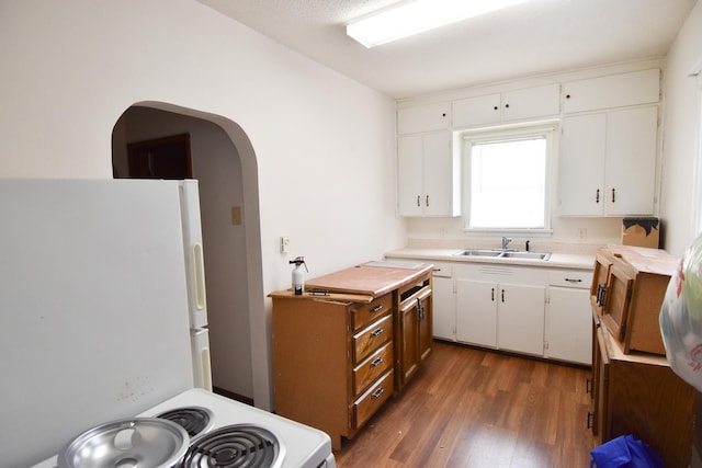 kitchen featuring sink, dark wood-type flooring, white cabinets, and white appliances