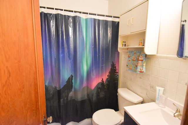 bathroom with a shower with curtain, vanity, toilet, and tile walls