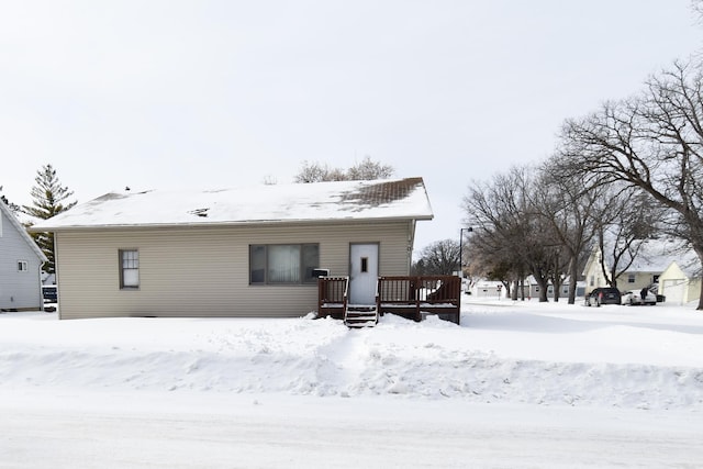 snow covered property with a wooden deck