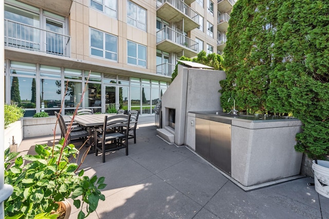 view of patio / terrace with an outdoor kitchen, exterior bar, and exterior fireplace