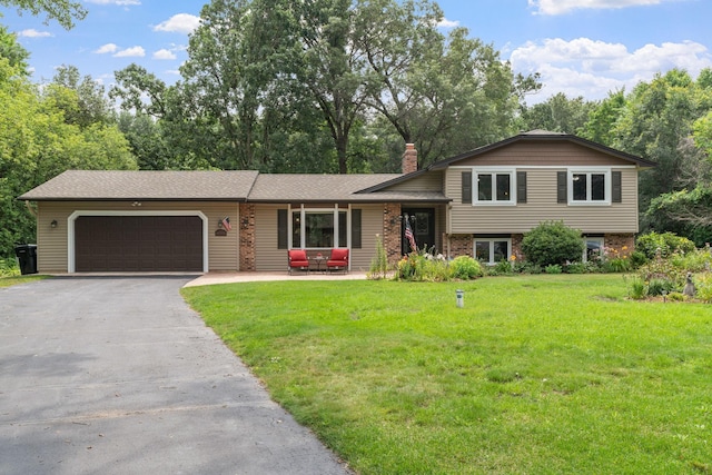 split level home with a garage and a front lawn