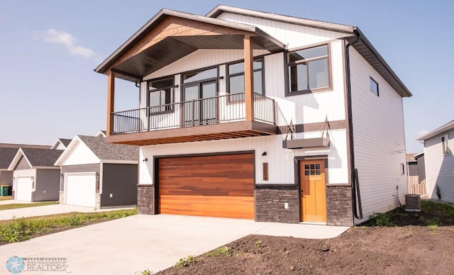 view of front of house featuring cooling unit, a balcony, and a garage