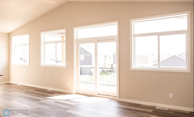 doorway with hardwood / wood-style flooring and vaulted ceiling