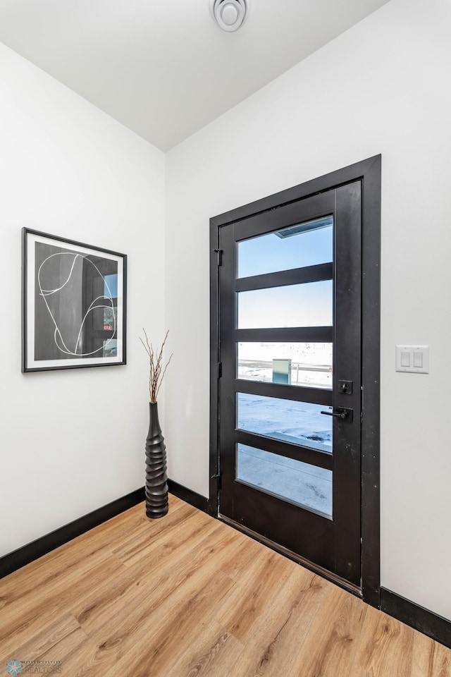 entryway with baseboards and wood finished floors