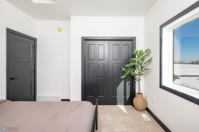 bedroom with carpet, visible vents, and a closet