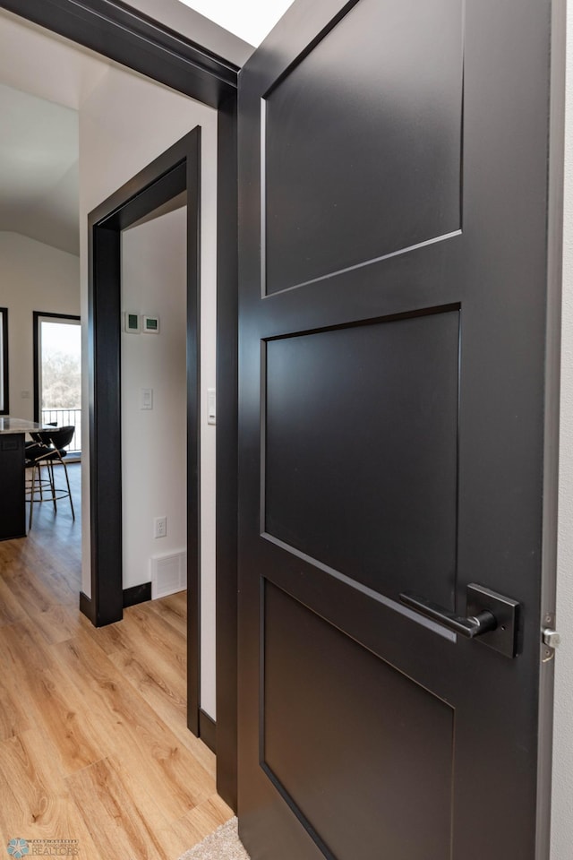 interior space featuring light wood-style floors, visible vents, and baseboards