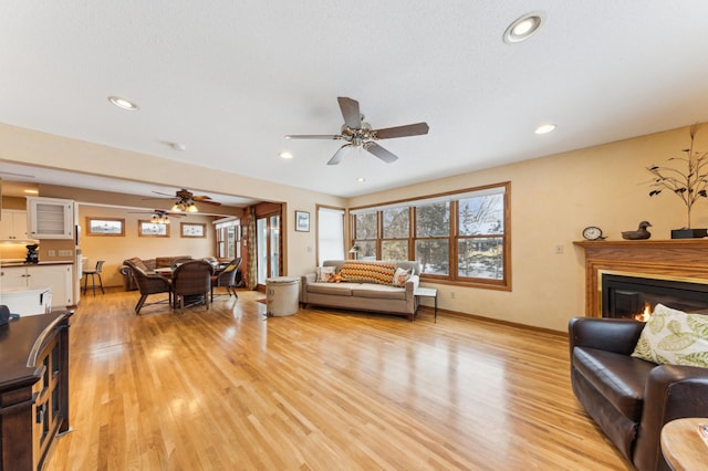 living room with ceiling fan and light wood-type flooring