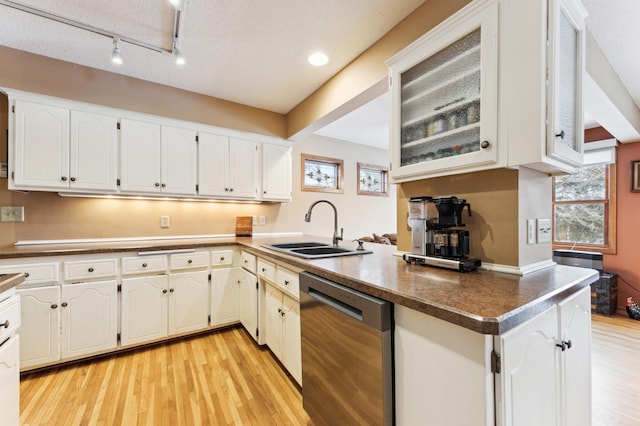 kitchen featuring white cabinets, light hardwood / wood-style flooring, dishwasher, and sink