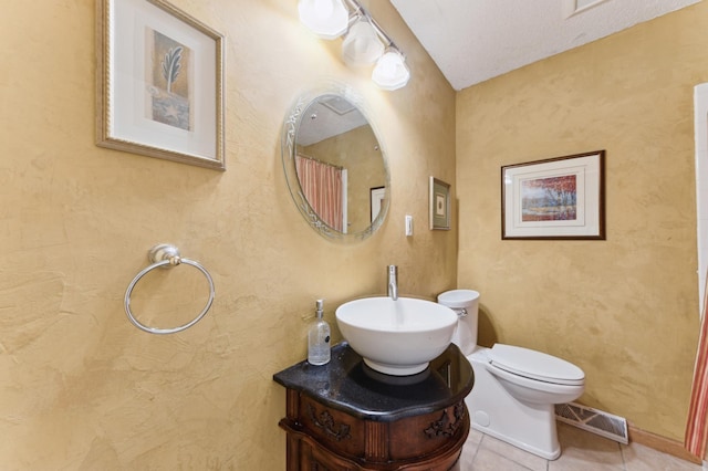 bathroom with toilet, tile patterned flooring, and vanity