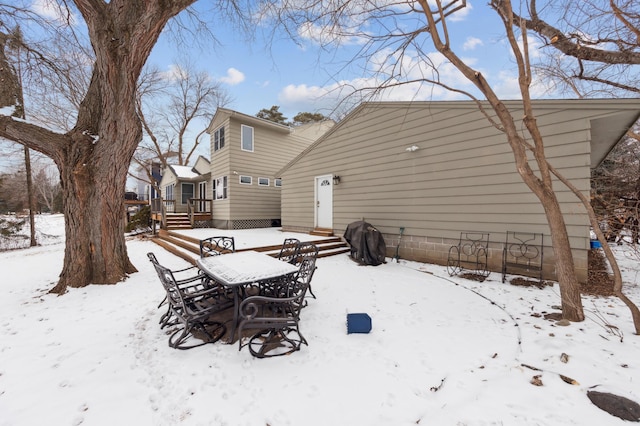 view of snow covered back of property