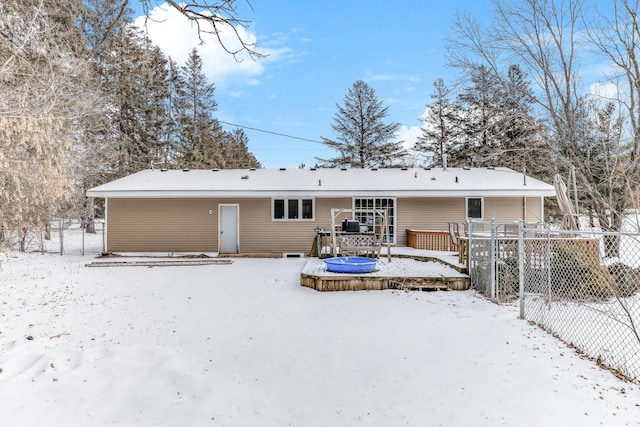 snow covered property featuring fence and a wooden deck