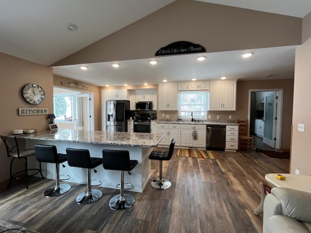 kitchen featuring a breakfast bar, sink, black appliances, kitchen peninsula, and white cabinets