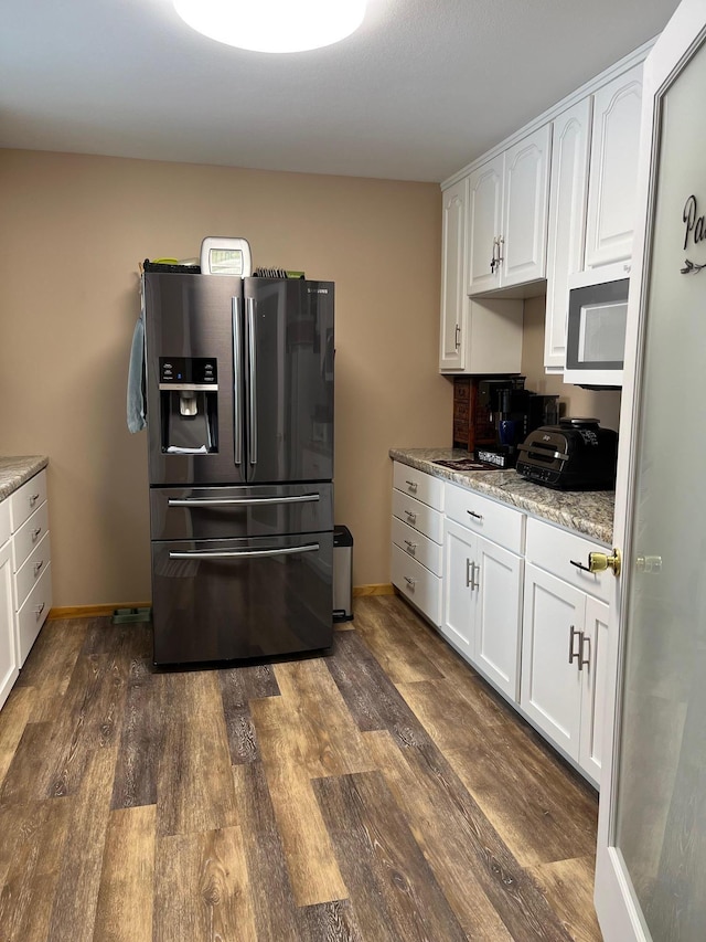 kitchen featuring white cabinetry, light stone countertops, and stainless steel refrigerator with ice dispenser