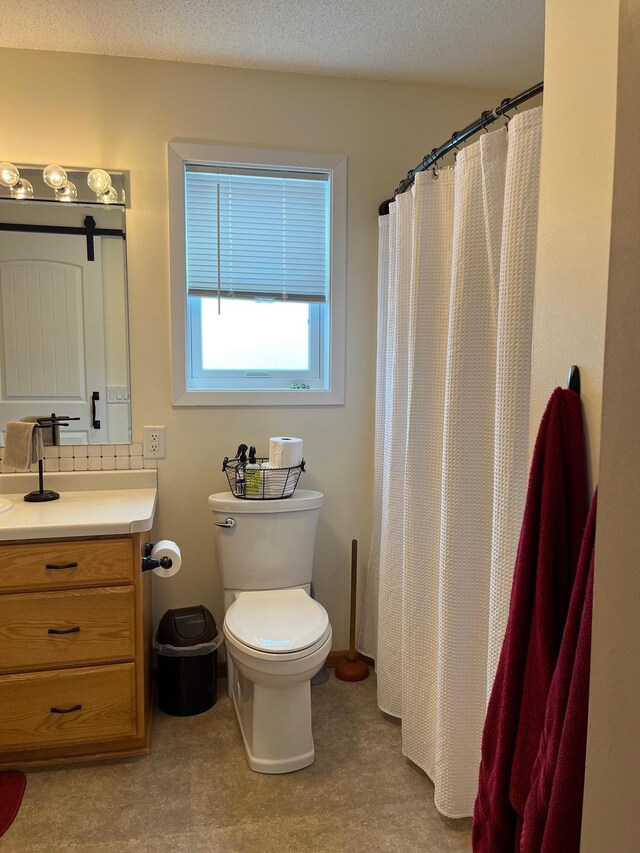 bathroom with vanity, curtained shower, toilet, and a textured ceiling