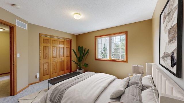 bedroom with light colored carpet, a closet, and a textured ceiling