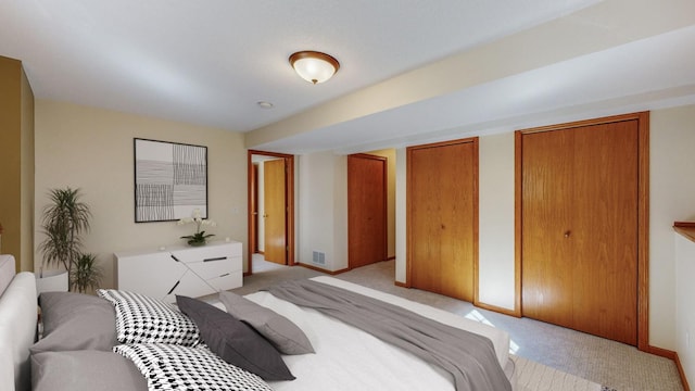 carpeted bedroom with multiple closets