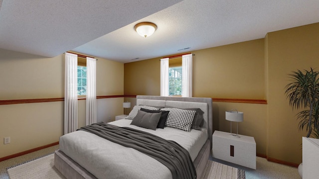 bedroom featuring light colored carpet and a textured ceiling