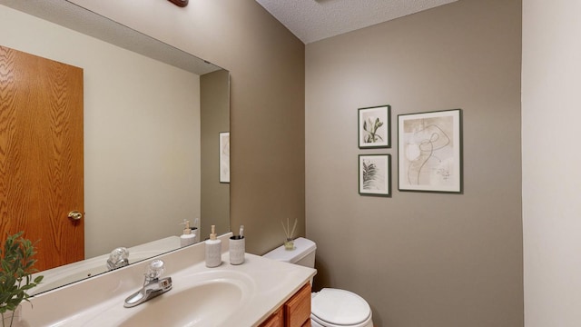 bathroom with vanity, a textured ceiling, and toilet