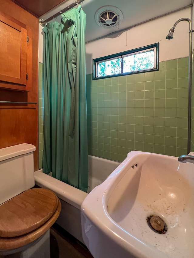 full bathroom featuring shower / tub combo, toilet, and sink