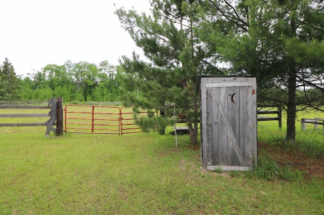 view of outbuilding featuring a rural view and a yard