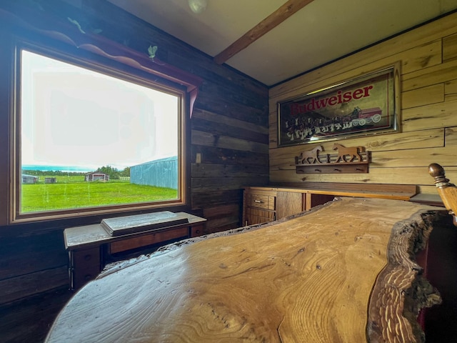 interior space featuring beamed ceiling and wood walls