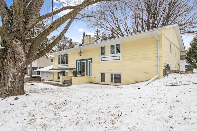 snow covered rear of property with cooling unit