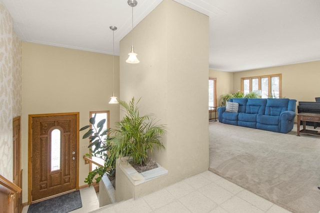 foyer featuring light colored carpet and a high ceiling