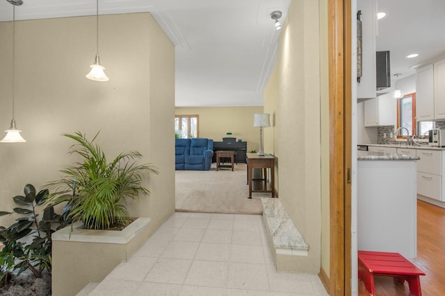 hallway featuring sink and a wealth of natural light