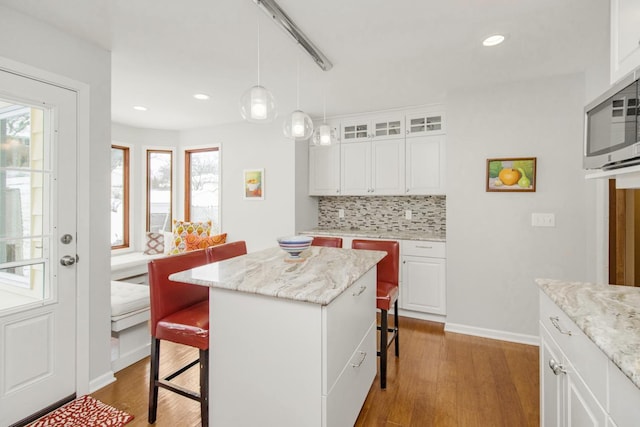 kitchen with white cabinetry, a center island, and a kitchen breakfast bar