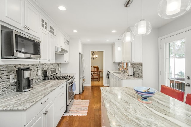 kitchen featuring light stone counters, stainless steel appliances, sink, and white cabinets