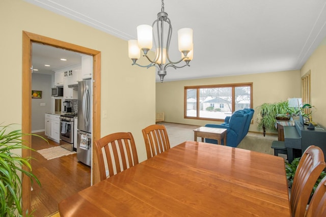 dining room with an inviting chandelier, hardwood / wood-style flooring, and radiator heating unit