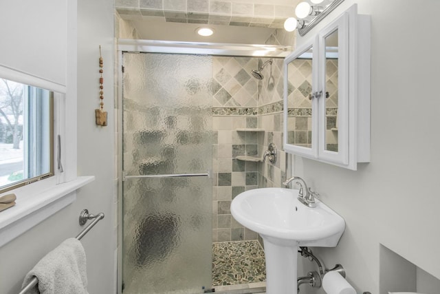 bathroom featuring sink and a shower with shower door