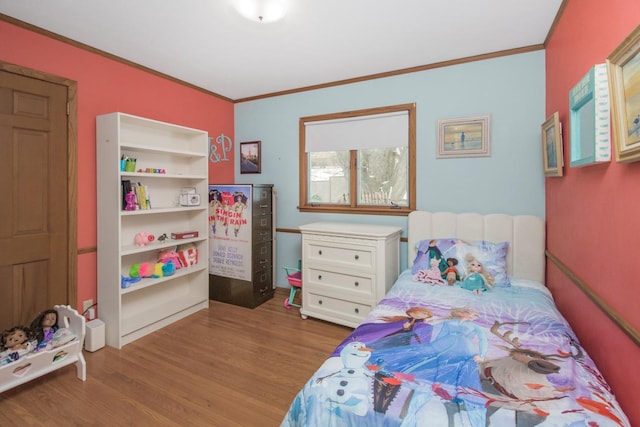 bedroom featuring ornamental molding and light hardwood / wood-style floors